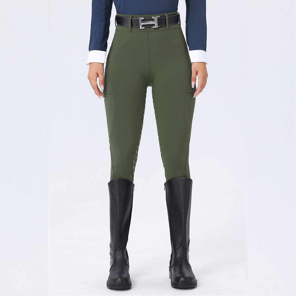 Person wearing green riding pants and black boots on a white background