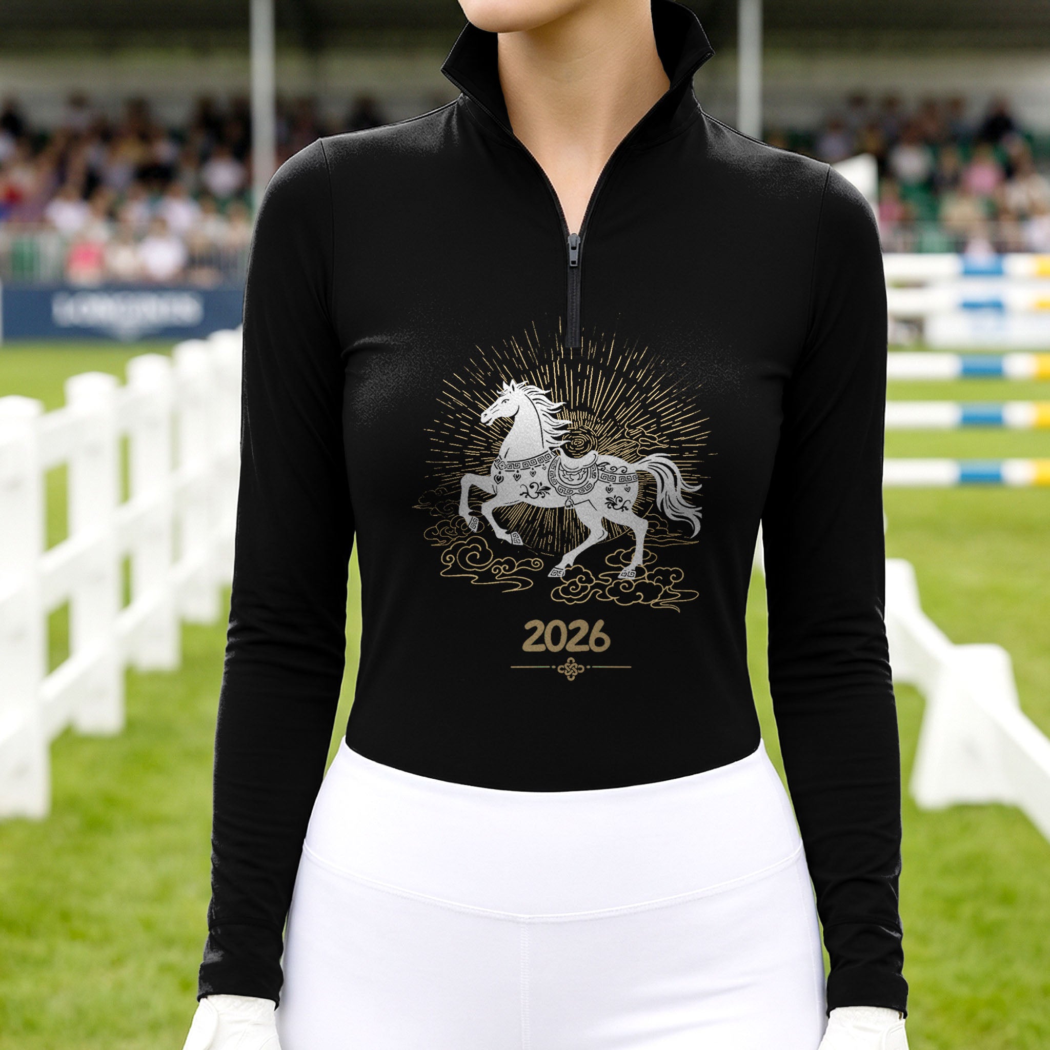 Model wearing the 2026 Year of the Horse Long-Sleeve Riding Top at a competition arena, with jumps in the background