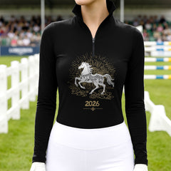 Model wearing the 2026 Year of the Horse Long-Sleeve Riding Top at a competition arena, with jumps in the background