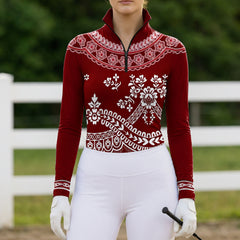 Model wearing burgundy lace floral horse riding top at outdoor equestrian jump arena
