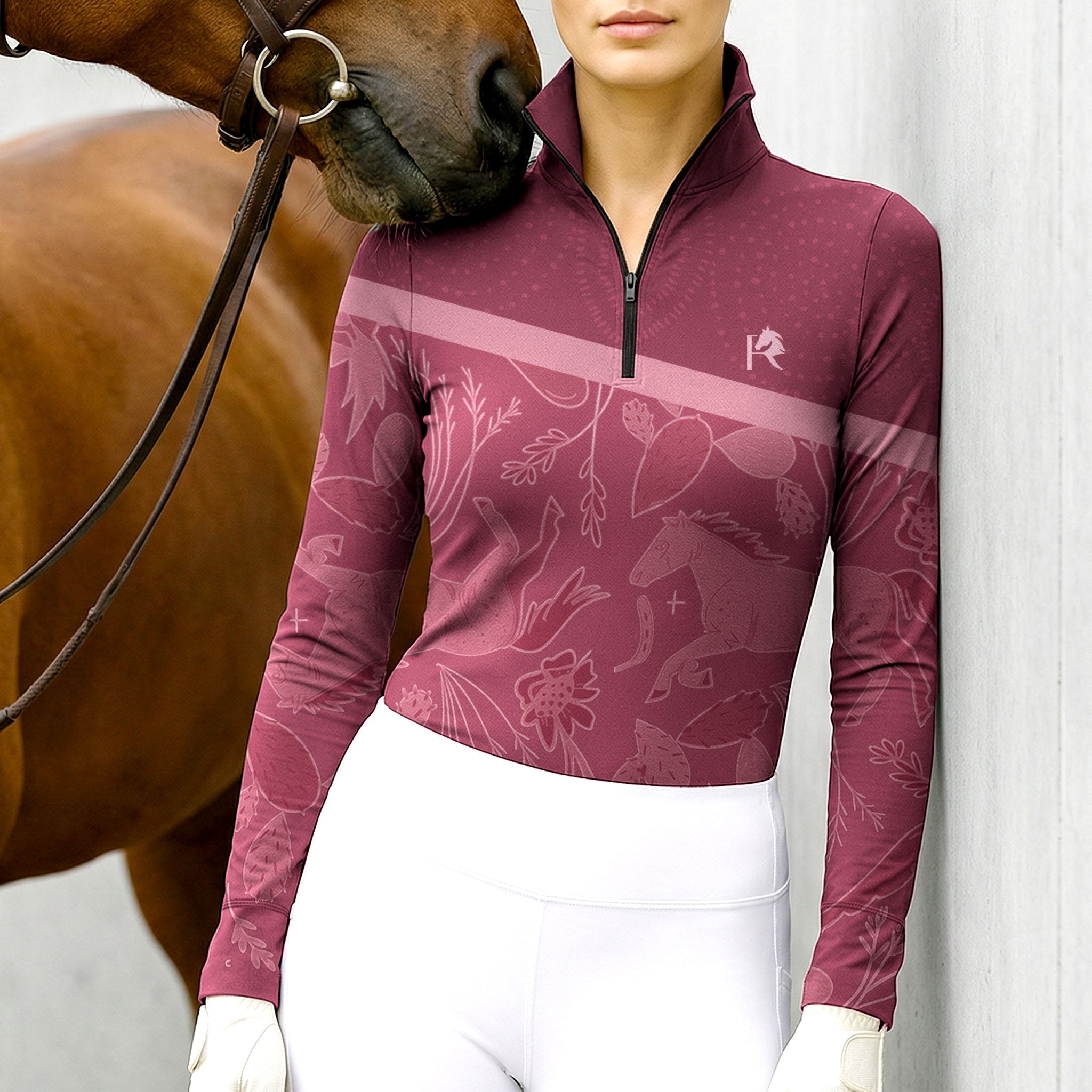 Model wearing the Burgundy Woodland Horse Print Long-Sleeve Riding Top at the stable, with a chestnut horse