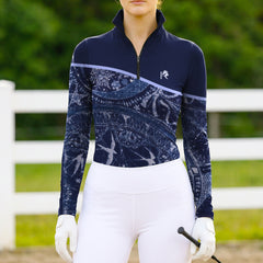 Model wearing the Celestial Night Print Color-Block Riding Top at an outdoor equestrian arena, with jumps in the background