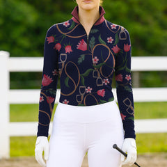 Model wearing romantic equestrian print riding top at sunlit green pasture