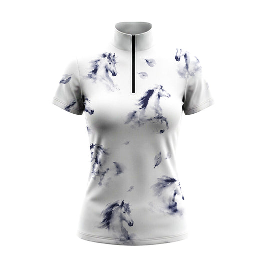 Bright sunlit white wooden stable walkway shot of model walking wearing crisp white scattered misty navy ink wash galloping horse leaf graphic equestrian short sleeve top