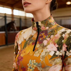 Model wearing mustard watercolor floral riding top inside wooden stable