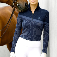 Person wearing a navy long-sleeve equestrian shirt with horse pattern, standing next to a horse.