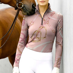Model wearing the Pink Equestrian Tack Print Long-Sleeve Riding Top at the stable, with a chestnut horse