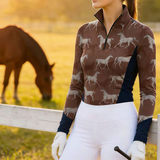 Woman wearing RIDER ATELIER sketch galloping horse quarter-zip top in the field at sunset with a horse