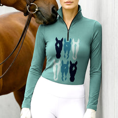 Woman wearing RIDER ATELIER teal stacked horse silhouette quarter-zip top at the outdoor pasture