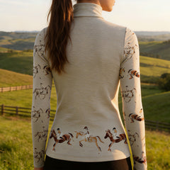 Woman wearing RIDER ATELIER watercolor show jumping quarter-zip top in the field at sunset