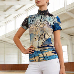 Model wearing tribal horse art riding top inside a bright indoor riding arena