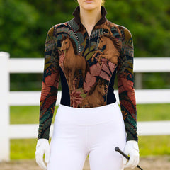 Full-body shot of model wearing boho jungle horse print riding top at sunlit green pasture fence