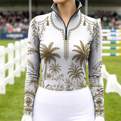 Model wearing tropical palm print riding top at outdoor equestrian show jumping arena