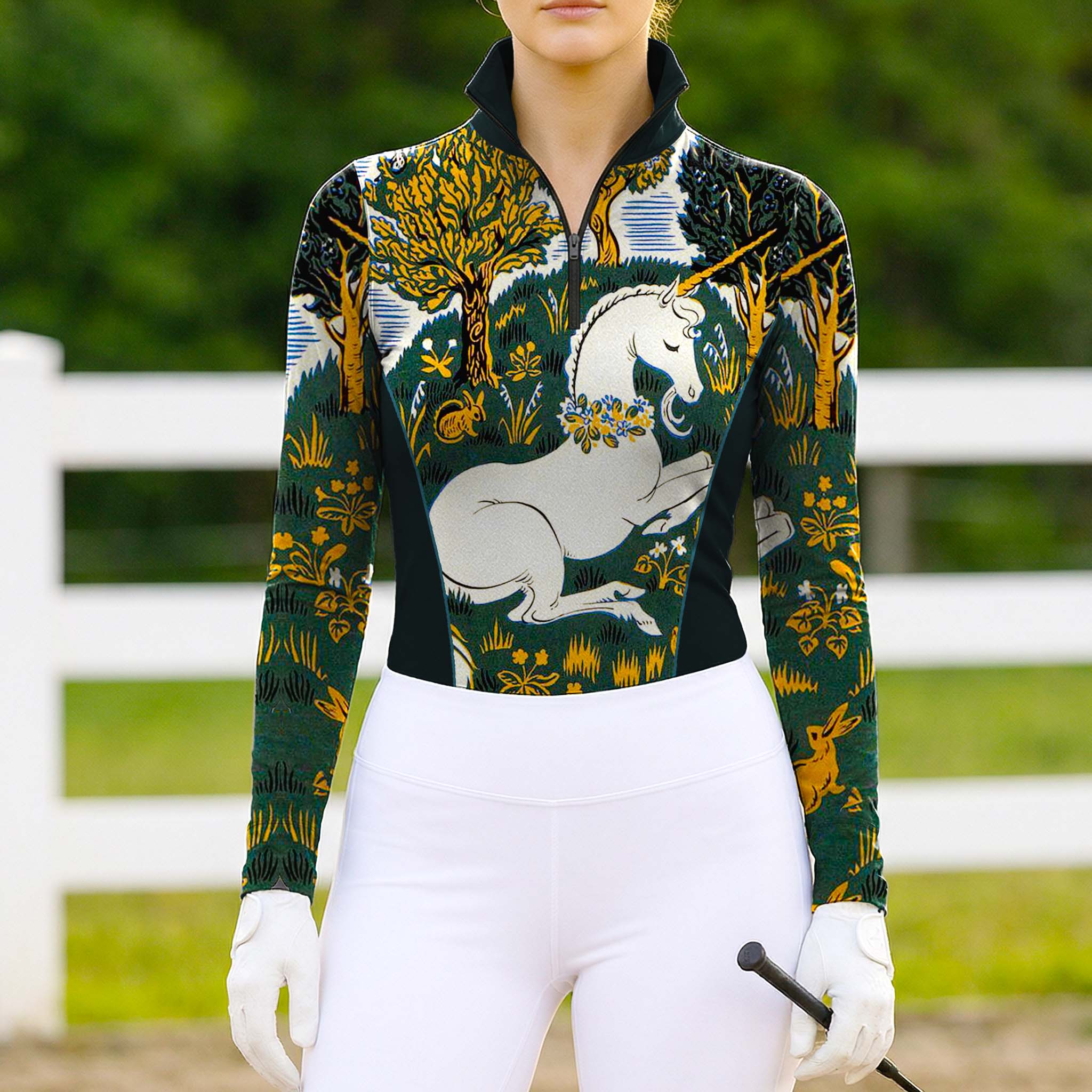 Model wearing whimsical forest print riding top at sunlit dirt equestrian arena