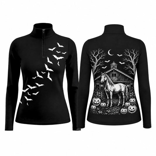 Barn fence lifestyle shot of two female equestrians, one showing back Halloween barn horse pumpkin print, other showing front bat silhouette on black long‑sleeve quarter‑zip riding top with white breeches and black riding gloves