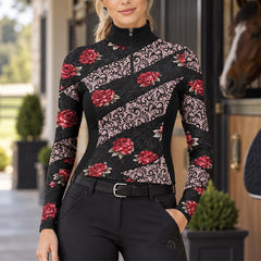 Rider wearing the printed top standing outside a wooden stable door with a horse visible nearby