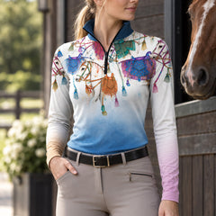 Woman wearing the riding top standing next to a brown horse at a stable entrance