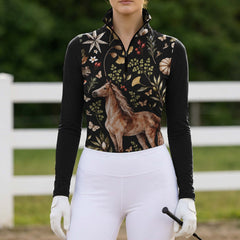 Woman wearing the black long sleeve quarter zip riding top with botanical horse print near horses
