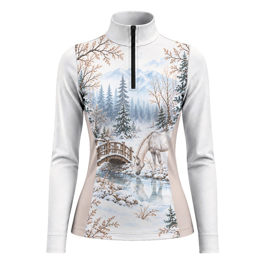 White long sleeve quarter zip riding top with a full front winter landscape print showing a horse drinking from a stream, snowy trees and mountains