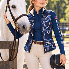 Reversible quilted equestrian vest in navy chain print styled with beige breeches and brown riding boots next to a white horse