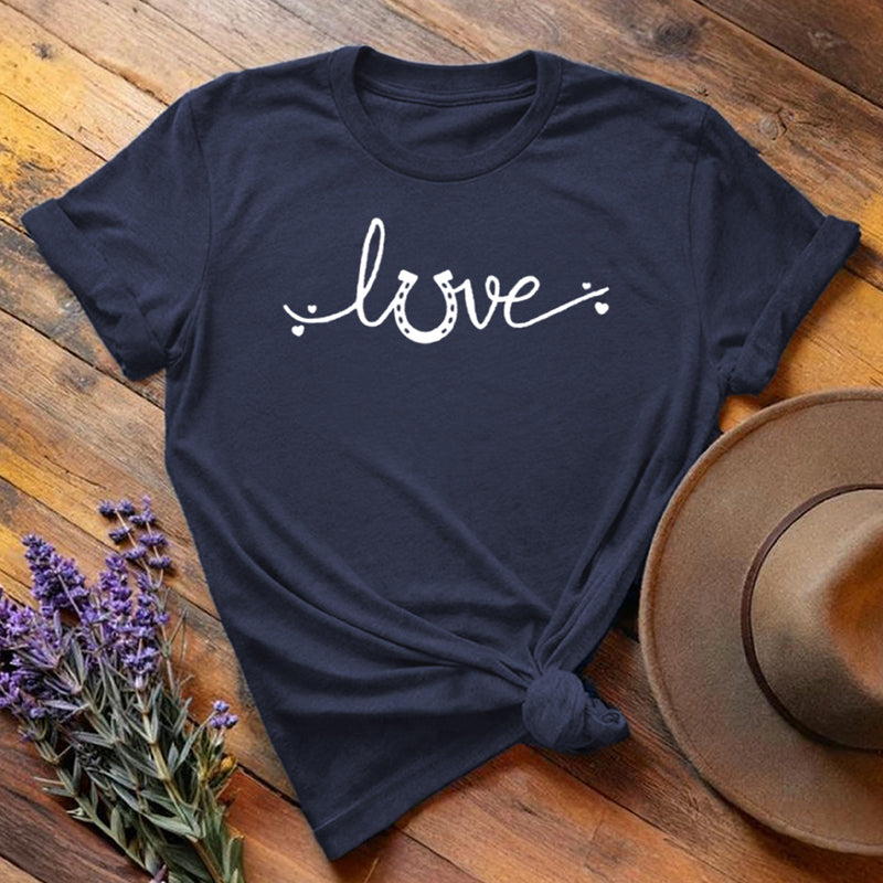 Navy blue horse shoe love equestrian t-shirt with white script print, flat lay on wooden background
