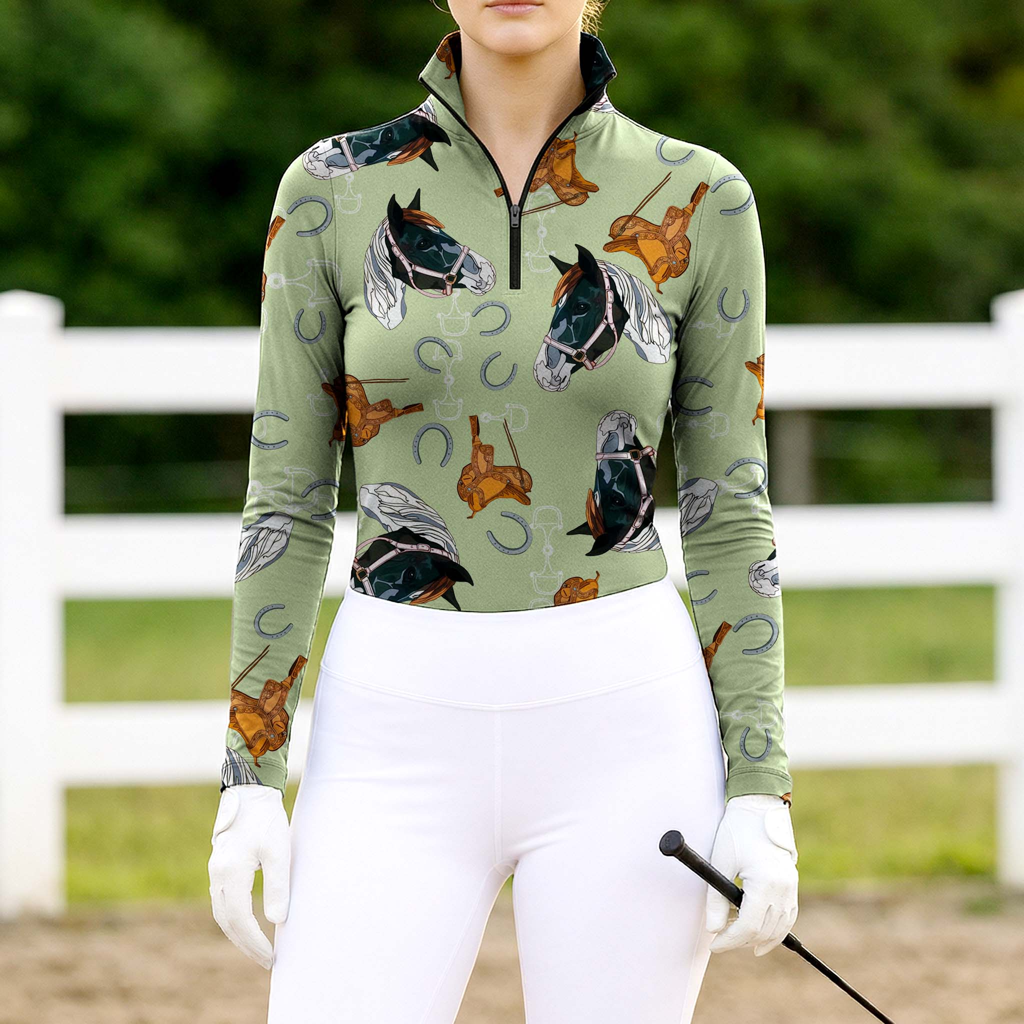 Woman wearing sage green western horse & saddle quarter-zip top at farm fence