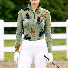 Woman wearing sage green western horse & saddle quarter-zip top at farm fence