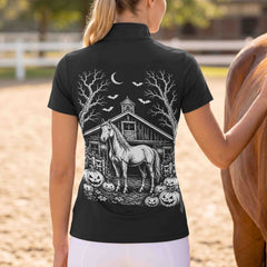 Outdoor arena back‑view shot of female rider wearing black short‑sleeve riding top with detailed spooky barn horse pumpkin bat moon Halloween back graphic and white breeches