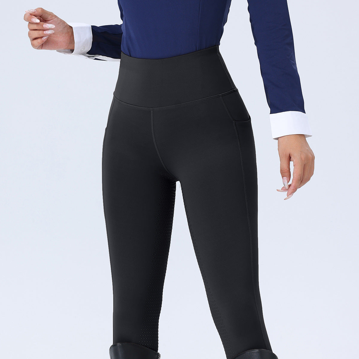 Person wearing black leggings with a blue top on a white background