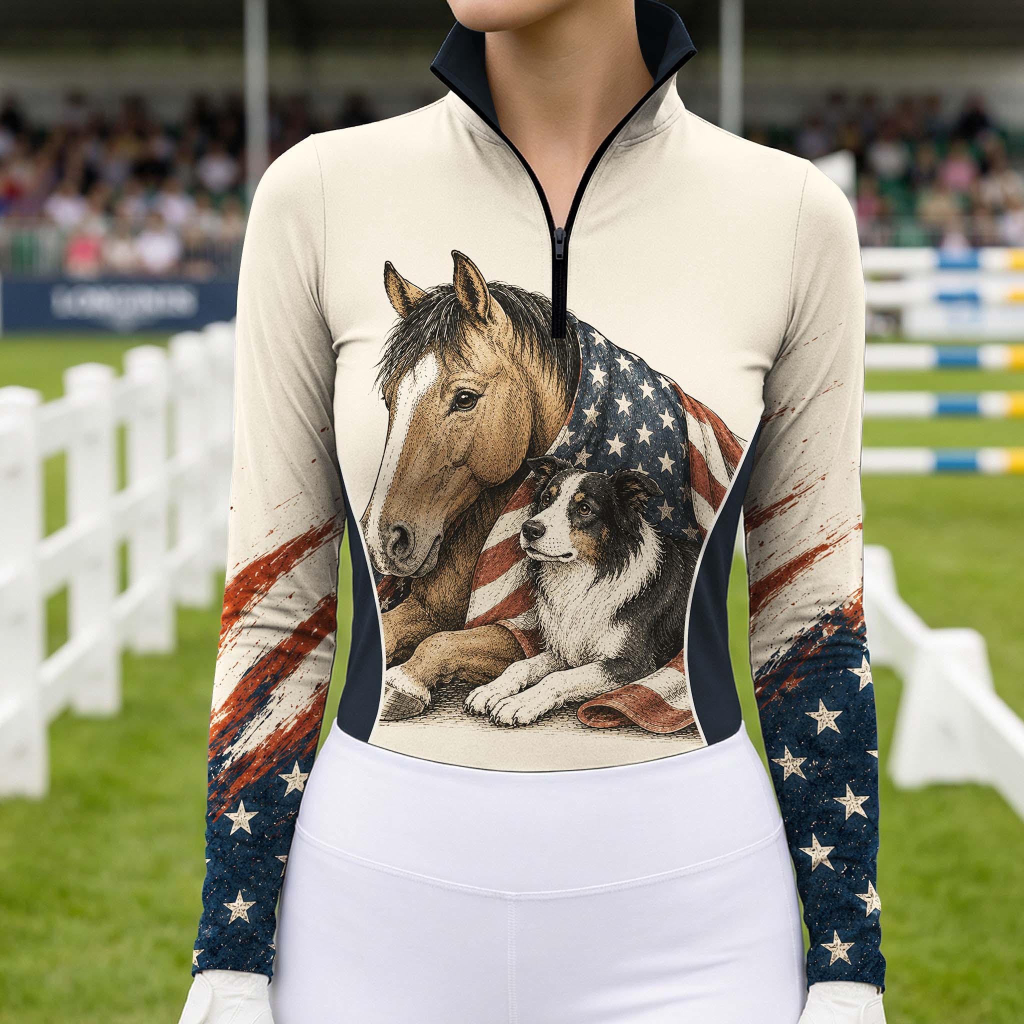 Outdoor show‑arena lifestyle shot of female equestrian wearing cream long‑sleeve riding top with horse border collie USA flag themed front graphic
