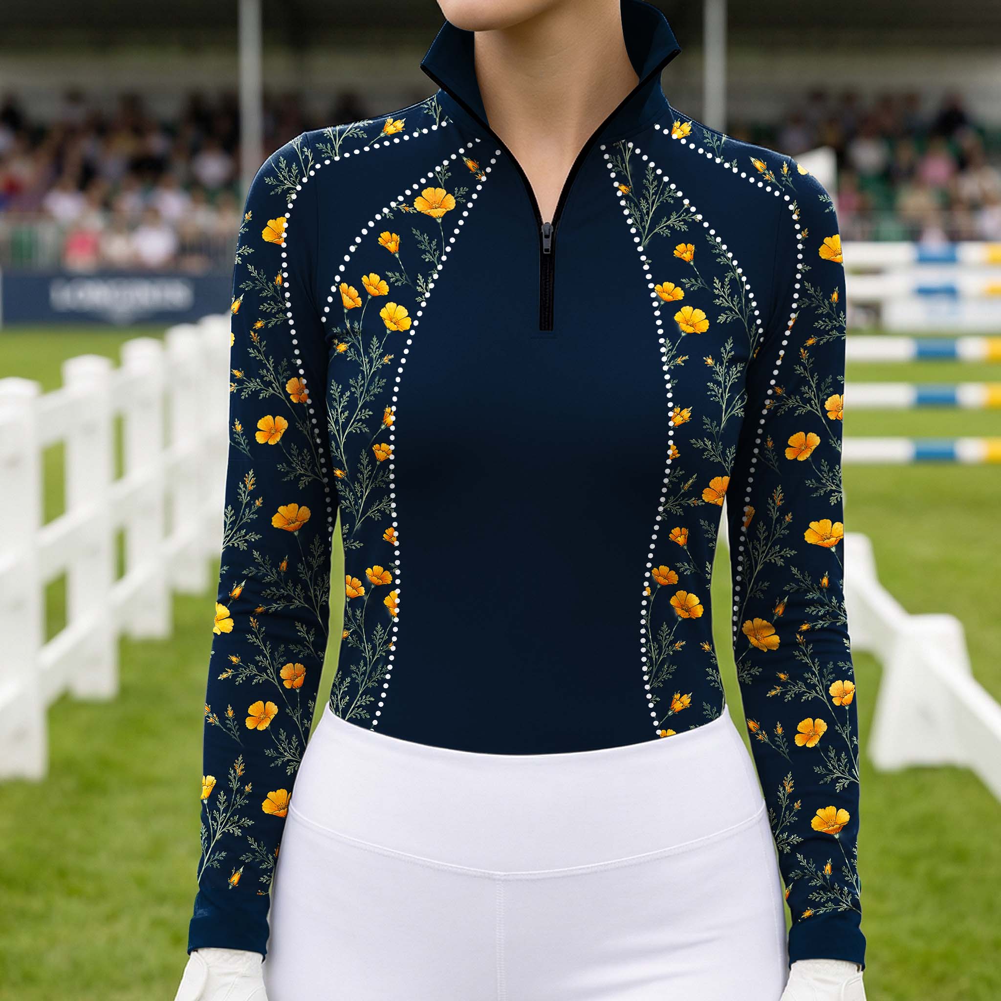 Outdoor competition show arena lifestyle shot of female equestrian wearing navy golden poppy floral rhinestone‑accent riding top