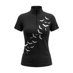White background studio product mockup of women’s black short‑sleeve quarter‑zip riding top decorated with cascading white flying bat silhouette print