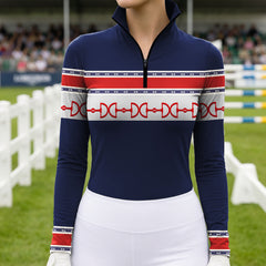 Outdoor grass show‑jumping arena lifestyle shot showcasing chest print detail of navy red‑white equestrian horse‑bit stripe long‑sleeve riding top with white breeches and riding gloves