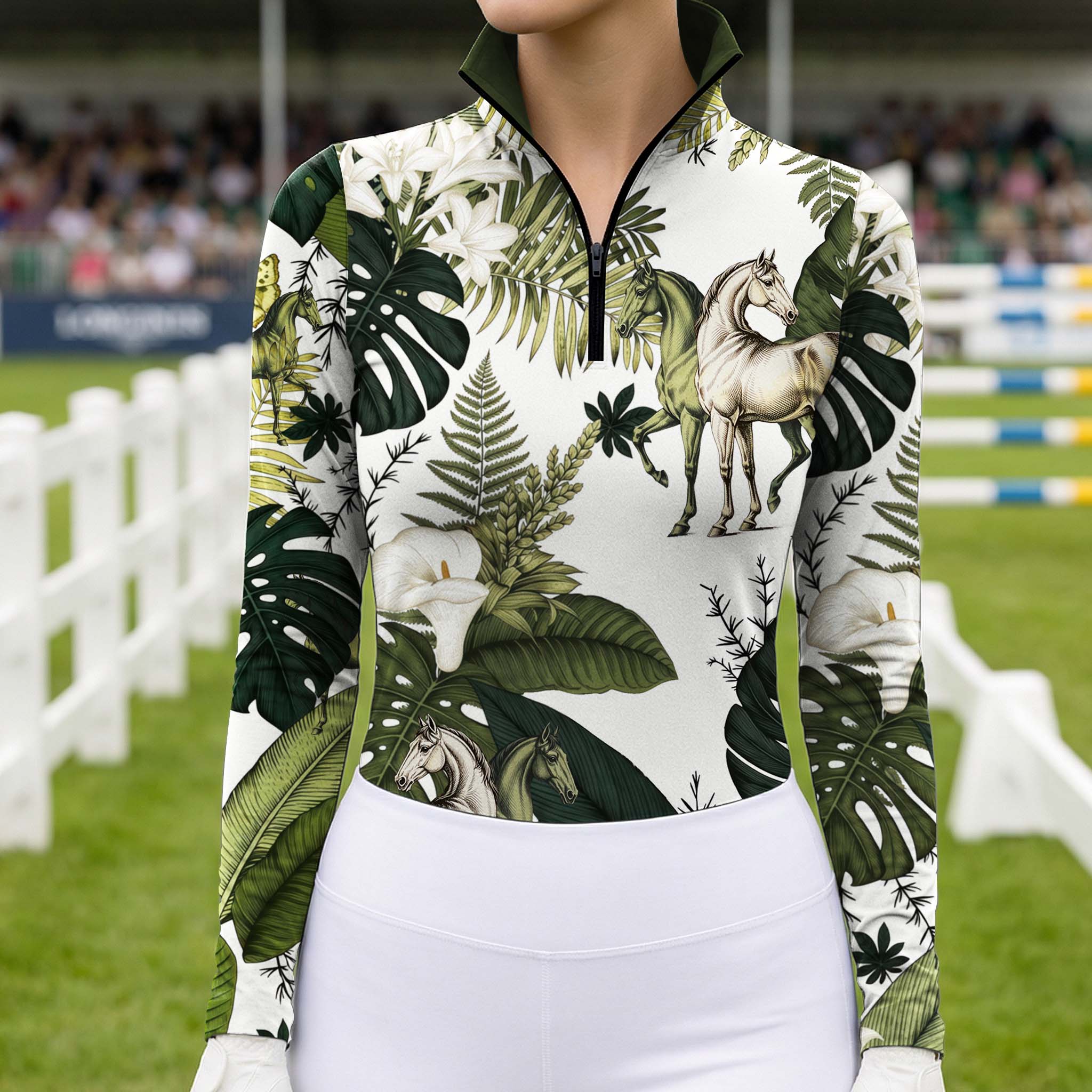 Outdoor competition show‑ground lifestyle shot of female rider wearing tropical foliage horse‑print long‑sleeve riding top with white breeches