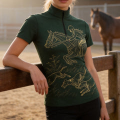Studio white‑background product mockup of black short‑sleeve quarter‑zip riding top with gold line‑art jumping rider and hunting hounds print