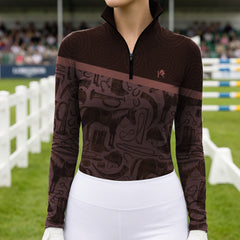 Outdoor competition show‑ground lifestyle shot of female equestrian wearing two‑tone brown long‑sleeve riding top with tonal tack‑collage silhouette print