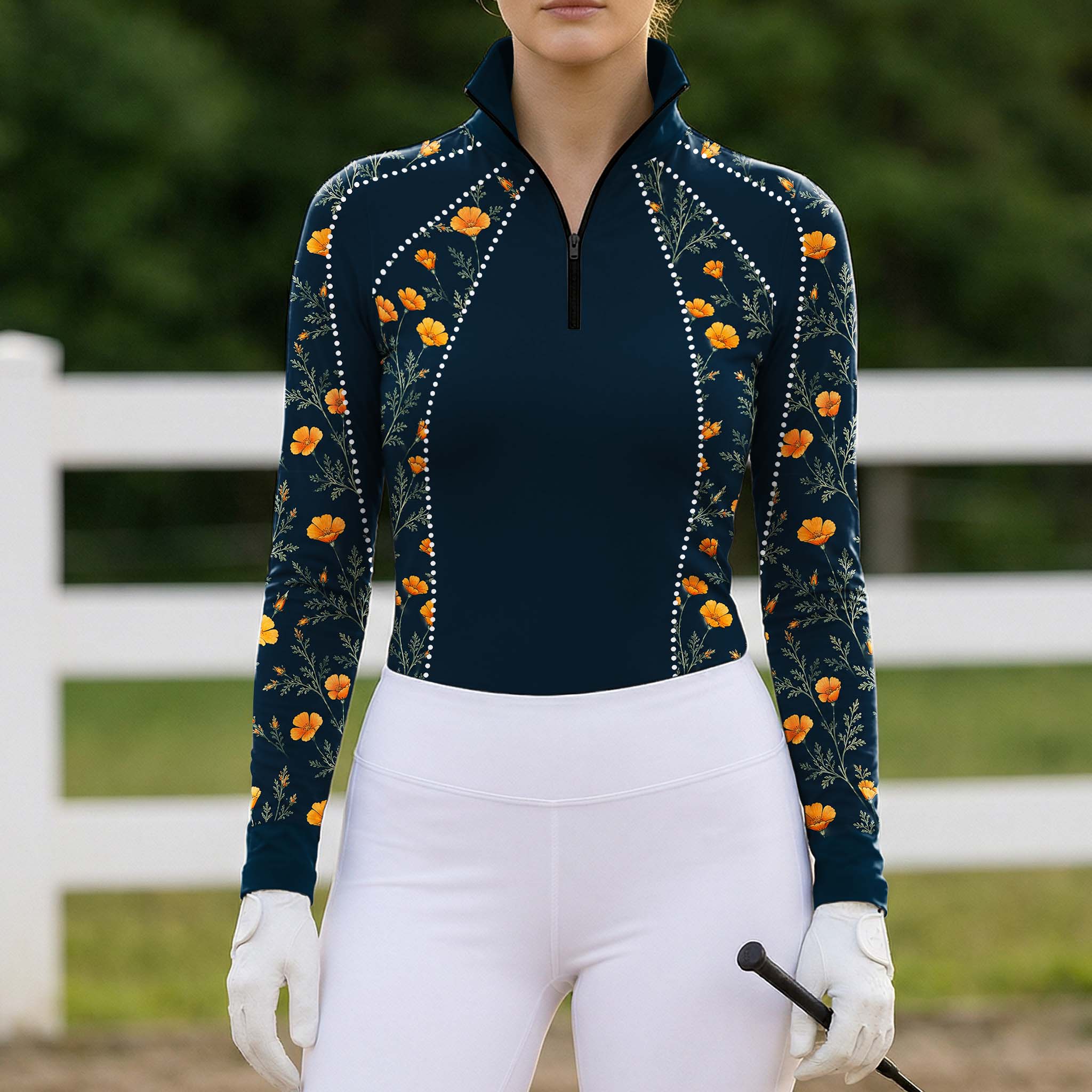 Outdoor pasture fence‑side lifestyle shot of female rider in navy golden california poppy floral print long‑sleeve riding top