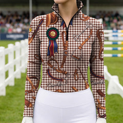 Sunny outdoor pasture front‑view lifestyle shot of female equestrian with hands on hips, wearing charcoal vintage tack zebra leopard print long‑sleeve riding top and white riding breeches