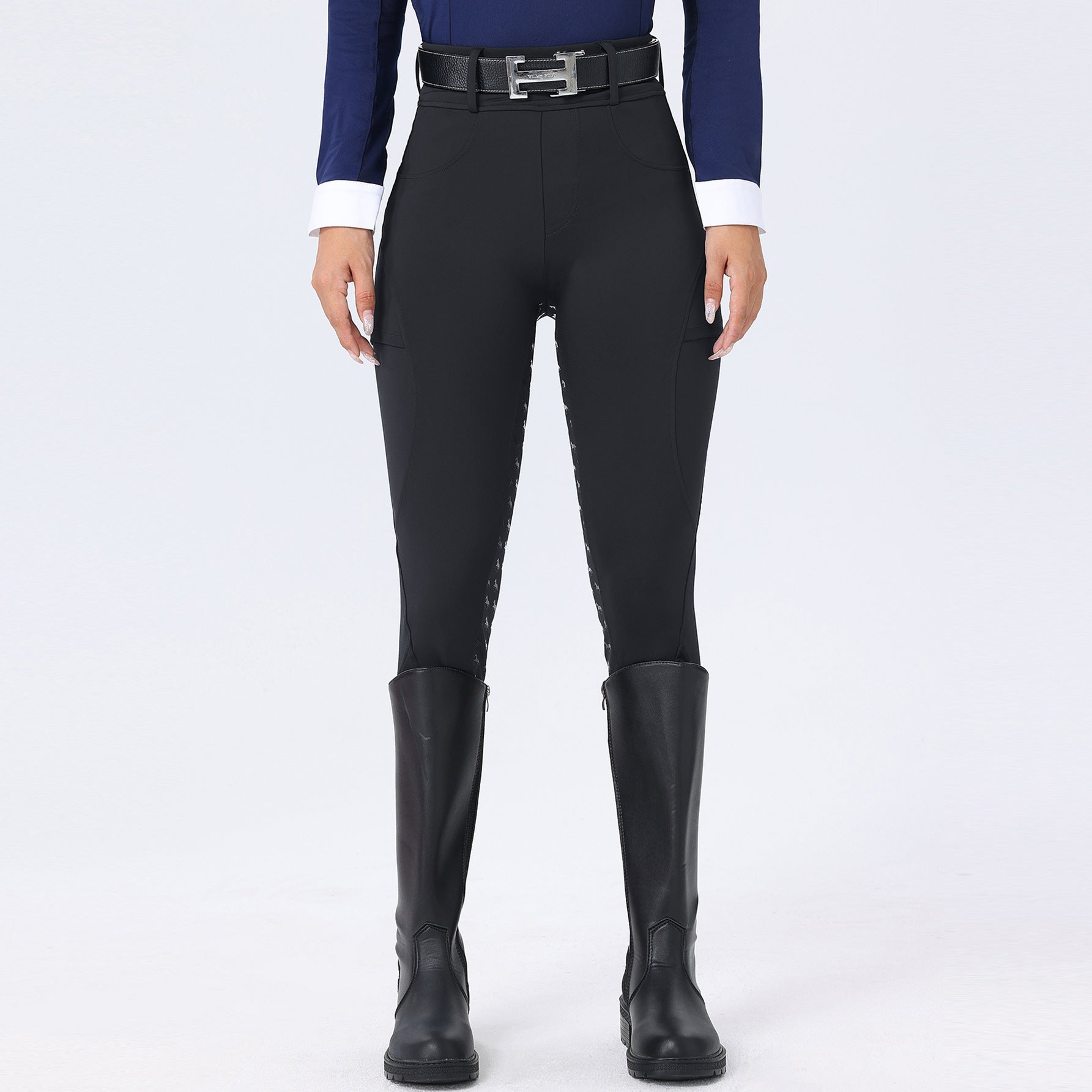 Person wearing black riding pants and boots on a white background