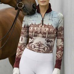 Neutral stone wall lifestyle shot of female equestrian as brown horse nuzzles her shoulder, wearing burgundy‑trim French chateau blueprint‑print long‑sleeve riding top and white breeches