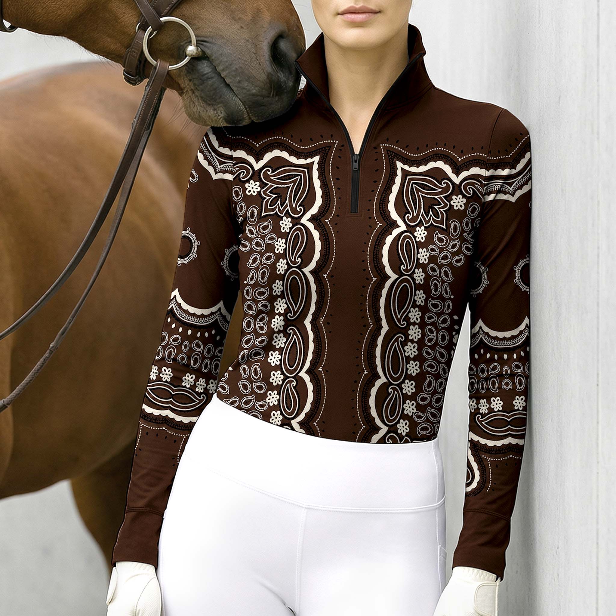 Clean white background studio product mockup of chocolate‑brown long‑sleeve quarter‑zip riding top with ornate cream‑white vintage bandana‑paisley floral all‑over front‑and‑sleeve print