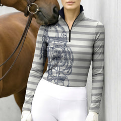 Wall‑side lifestyle shot of female equestrian wearing grey‑white stripe bridle‑tack print riding top standing next to brown horse