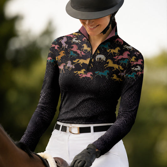 Clean white background studio product mockup of black long‑sleeve quarter‑zip riding top with multi‑color galloping horse yoke print and contrasting pink inner collar
