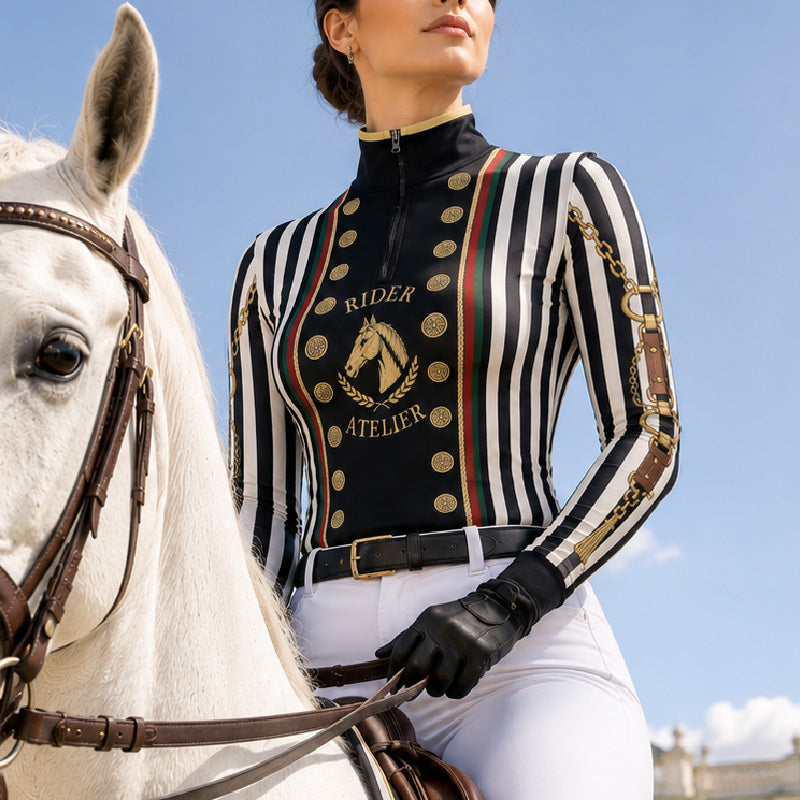 Show‑event close‑up detail shot of female rider wearing black‑white stripe vintage military‑inspired long‑sleeve quarter‑zip riding top and white riding breeches