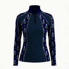 Close‑up stable interior shot of women’s navy long‑sleeve quarter‑zip riding top with bluebonnet floral print and rhinestone‑dot panel trim focusing on collar and shoulder details