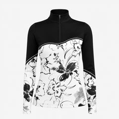 Sunny sandy paddock lifestyle shot of female equestrian beside grey horse, wearing black‑white color‑block ink‑wash floral print long‑sleeve riding top and black riding breeches