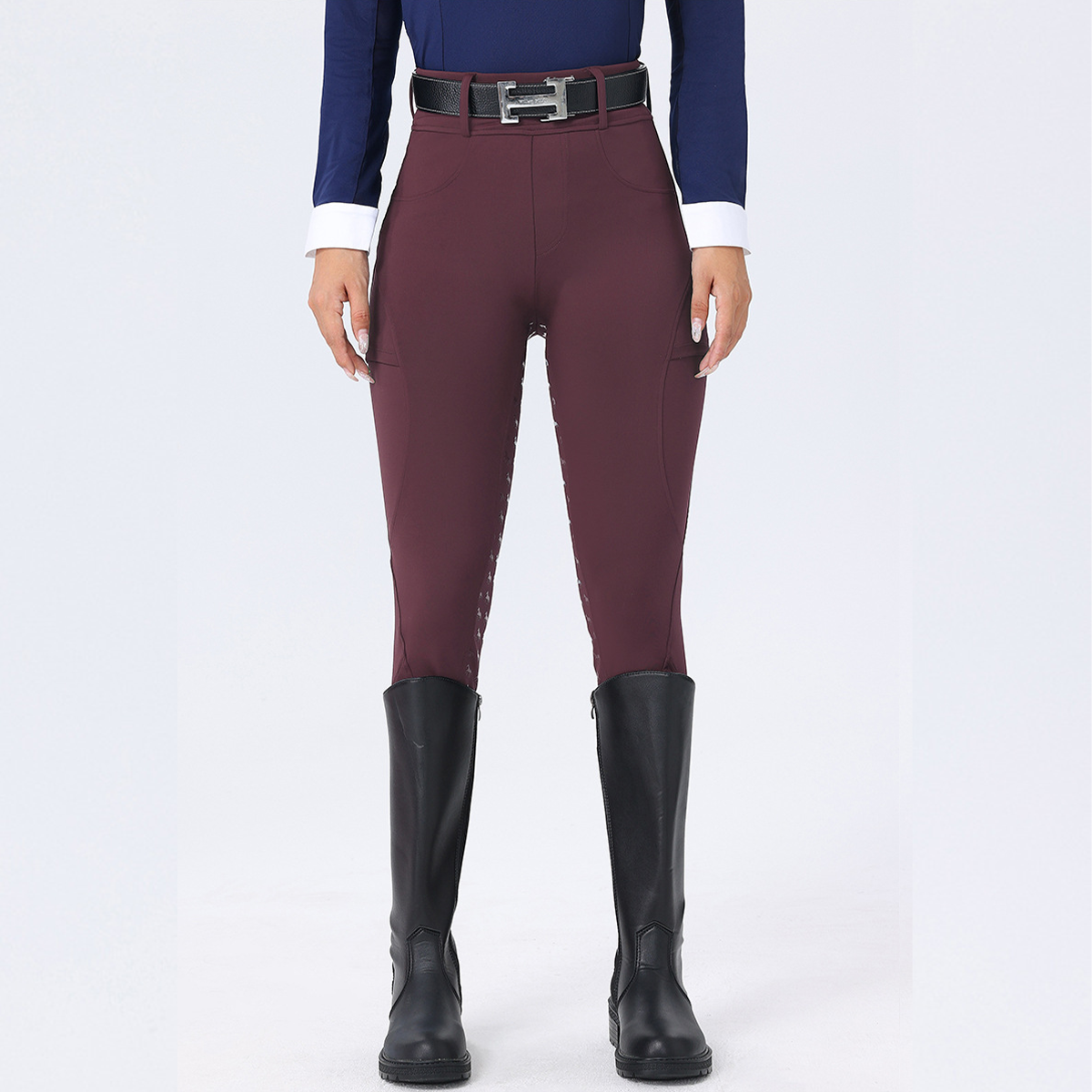 Maroon riding pants with black boots on a white background