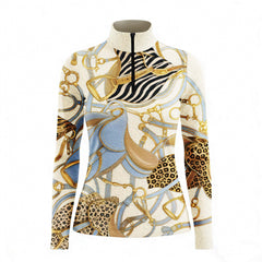 Sunset ranch lifestyle shot of female equestrian seated in saddle holding iced drink, wearing cream vintage equestrian tack zebra leopard mixed‑print long‑sleeve riding top and black riding breeches