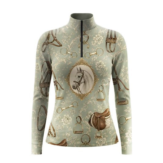 White background studio shot of muted sage green antique tack and framed horse portrait long sleeve quarter zip riding top