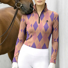 Lifestyle shot of female rider wearing pastel peach‑lavender argyle diamond riding top leaning beside brown horse